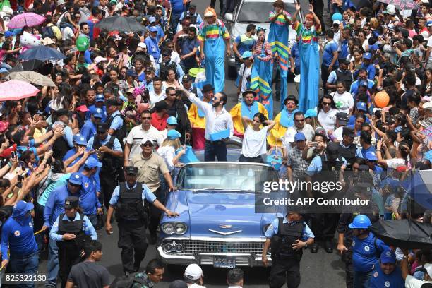 The Mayor of San Salvador Nayib Bukele throws candy during a parade marking the start of San Salvador's patron saint's festival in honor of Divino...