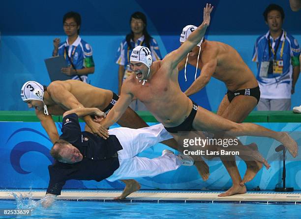 Head coach Denes Kemeny of Hungary is thrown into the water by Norbert Madaras, Norbert Hosnyanszky and Gabor Kis after they won the gold medal by...