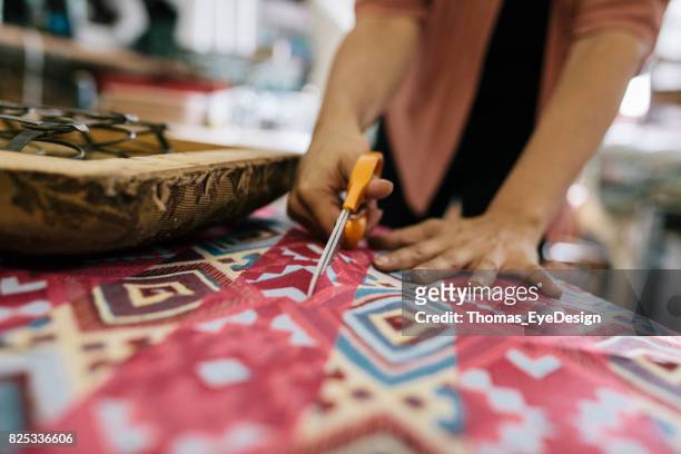 close-up craftswoman snijden kleurrijke stof op maat - upholstry stockfoto's en -beelden