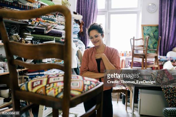 Craftswoman In Upholstery Studio, Admiring Her Latest Piece