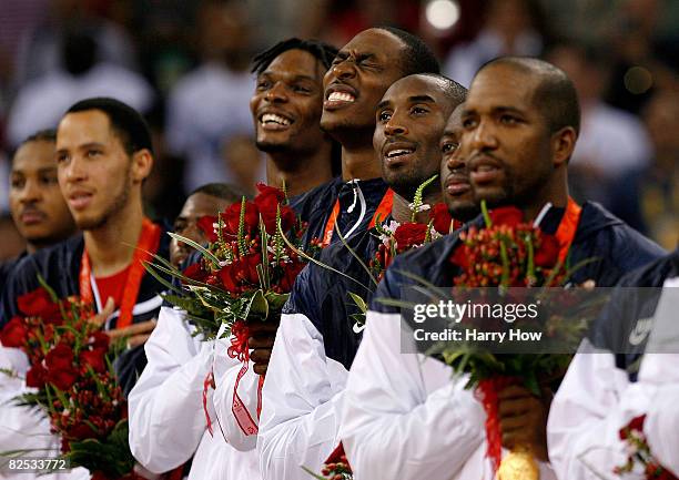 Chris Bosh, Dwight Howard and Kobe Bryant of the United States stand on the podium during the national anthem after defeating Spain in the gold medal...