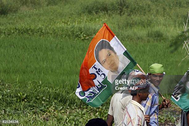 Trinamool Congress activists carry party flags as they march to attend an indefinite agitation in front of the main entrance of the Tata car plant at...