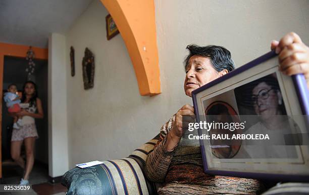 Yolanda Cubo holds the portrait of Colombian drug lord Pablo Escobar at her house of the Pablo Escobar neighborhood -500 houses built by him for the...