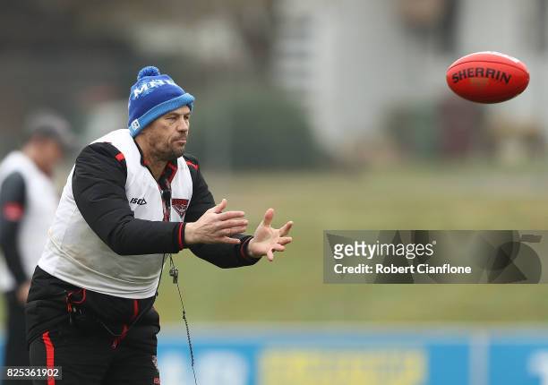 Performance coach Mark Harvey throws the ball during an Essendon Bombers AFL training session at the Essendon Bombers Club on August 2, 2017 in...