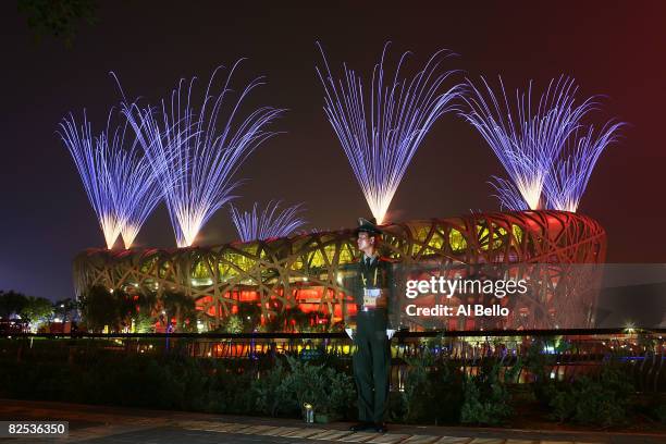 Guard stands watch as fireworks go off during the Closing Ceremony for the Beijing 2008 Olympic Games on August 24, 2008 in Beijing, China.