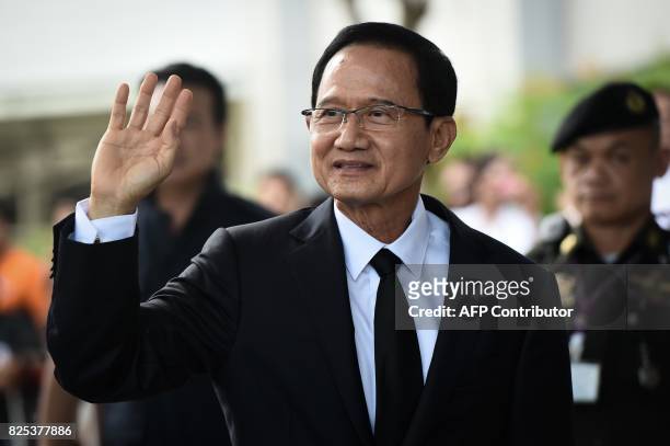 Former prime minister Somchai Wongsawat, brother-in-law of Thaksin and Yingluck Shinawatra, waves to supporters as he arrives at the Supreme Court in...