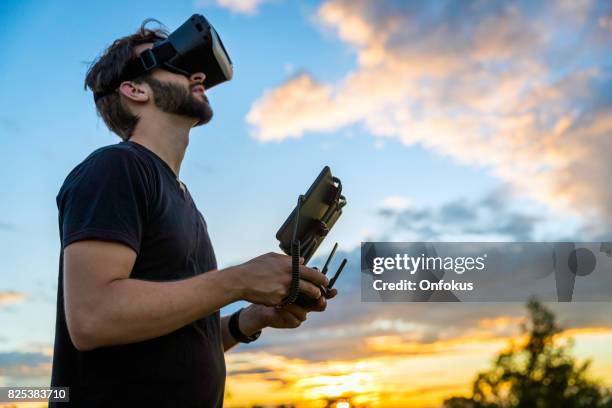 仮想現実ゴーグル ヘッドセットとドローンを飛ぶ��男 - flying goggles ストックフォトと画像