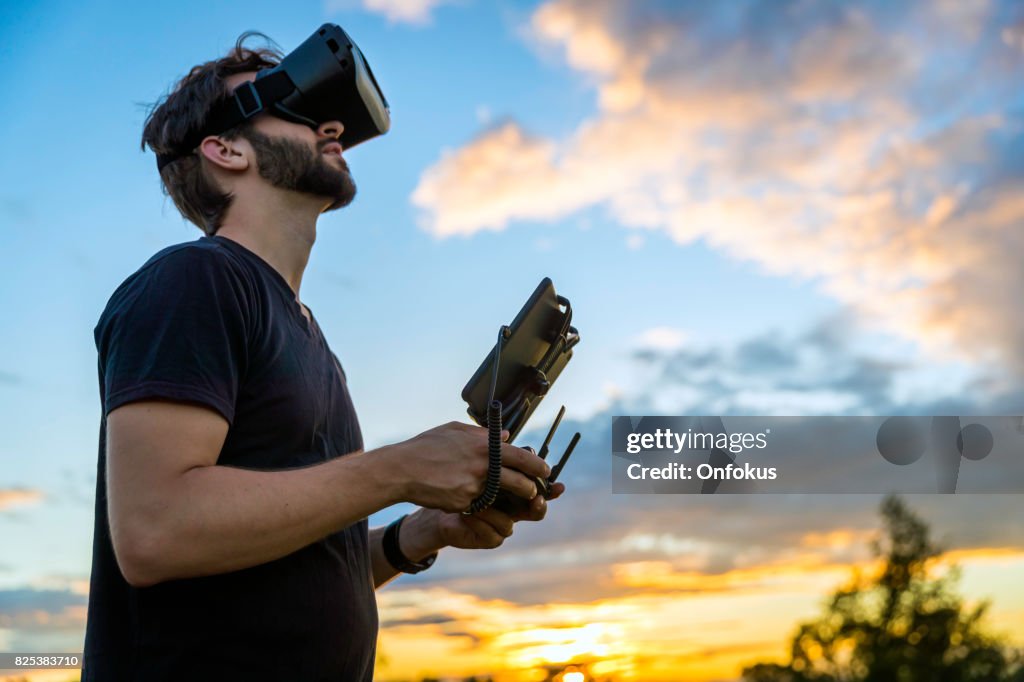 Man Flying a Drone with Virtual Reality Goggles Headset