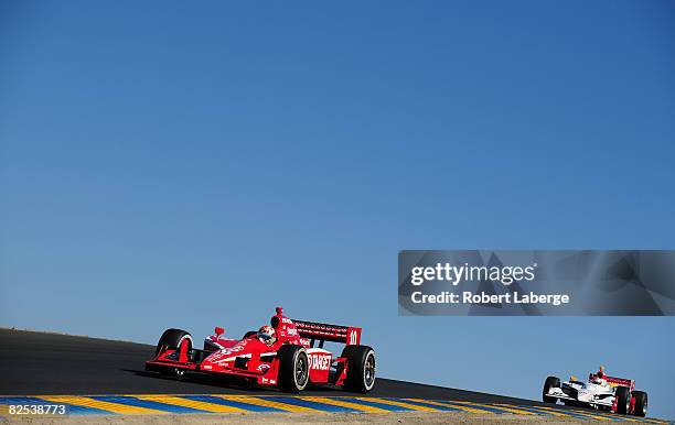 Dan Wheldon driver of the Target Chip Ganassi Racing Dallara Honda leads Mario Dominguez during the IndyCar Series PEAK Antifreeze & Motor Oil Indy...