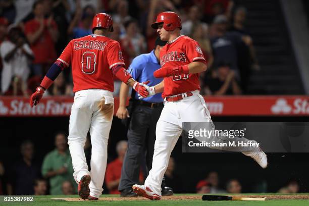 Yunel Escobar congratulates Mike Trout after scoring on a double by Albert Pujols of the Los Angeles Angels of Anaheim during the fifth inning of a...