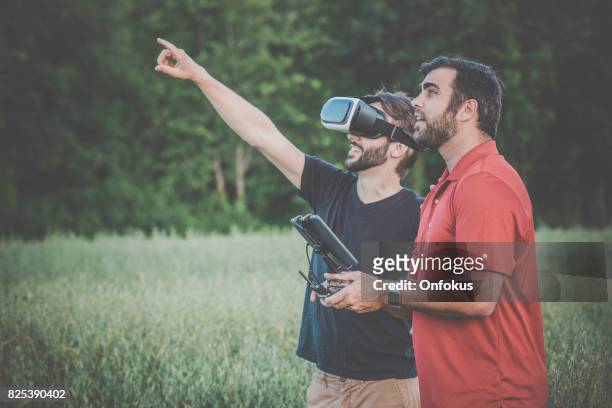 friends using drone and virtual reality headset outdoor - beard pilot stock pictures, royalty-free photos & images
