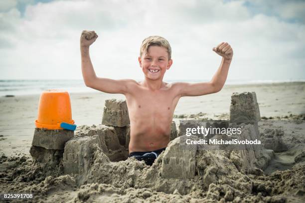 blonde junge am strand eine sandburg bauen - kind sandburg stock-fotos und bilder