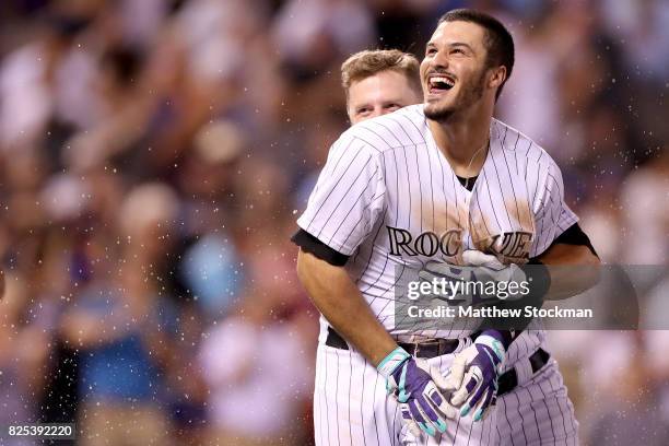 Nolan Arenado of the Colorado Rockies celebrates with Mark Reynolds after driving in the game winning run in the ninth inning against the New York...