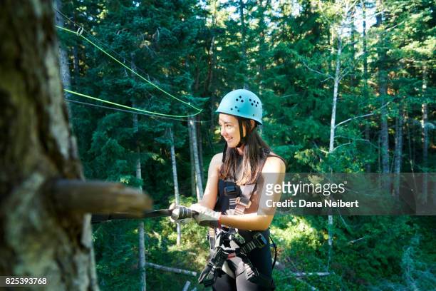 girl posing with zip line equipment - canopy fotografías e imágenes de stock