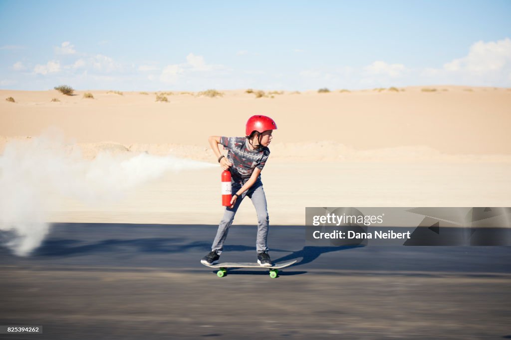 Boy riding skateboard propelled by fire extinguisher