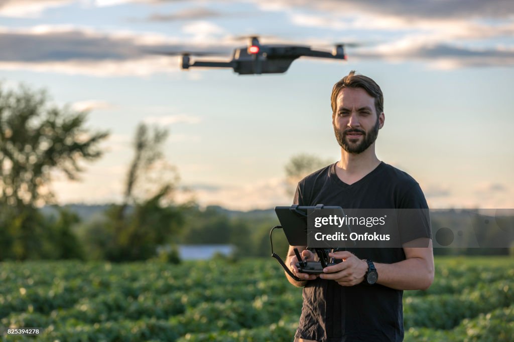Man Pilot Using Drone Remote Controller at Sunset