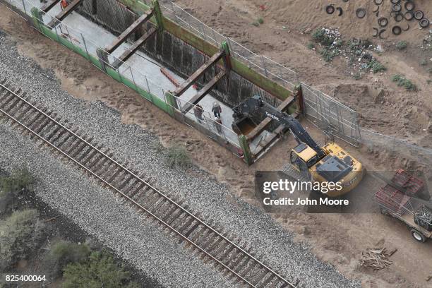 Construction crew works on a new section of the U.S.-Mexico border fence on August 1, 2017 as seen from a U.S. Customs and Border Protection...