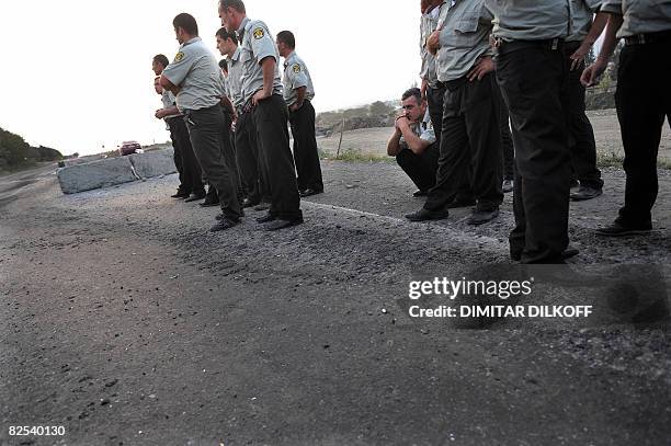 Georgian policemen wait at the last checkpoint on the Gori-Tbilisi road on August 22 near the village of Khurvaleti. Hundreds of soldiers and columns...