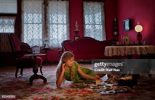 girl looking at old pictures - lying on back girl on the sofa stock pictures, royalty-free photos & images