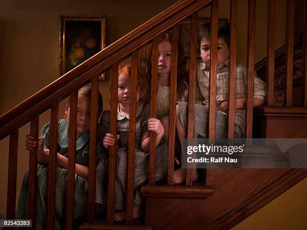 siblings spying through staircase banister - family tree stockfoto's en -beelden