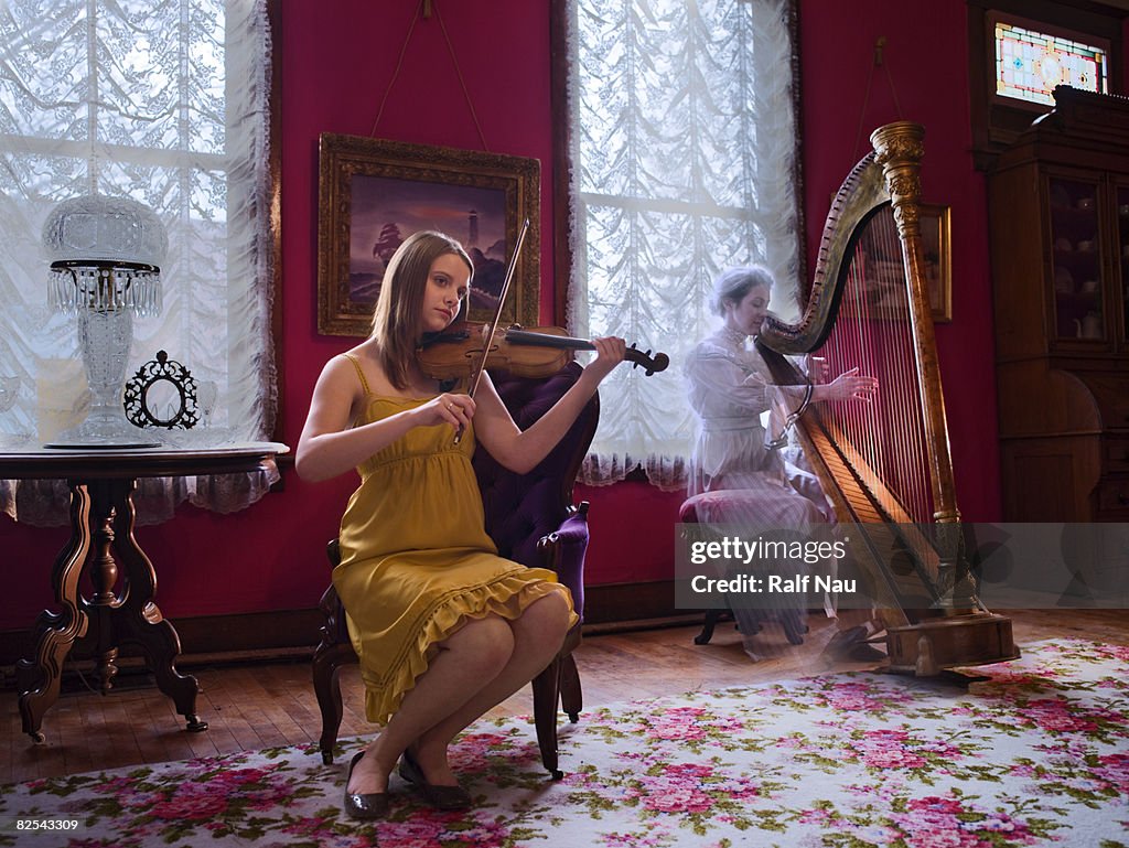 Girl playing violin with ghost presence in room