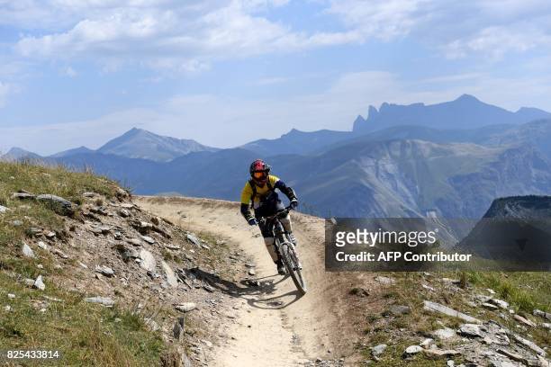 Biker rides his mountain bike on a trail on July 31, 2017 in Les Deux Alpes bike park in the French Alps, eastern France. A network of around 100km...
