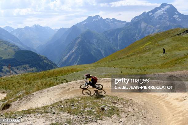 Biker rides his mountain bike on a trail on July 31, 2017 in Les Deux Alpes bike park in the French Alps, eastern France. A network of around 100km...