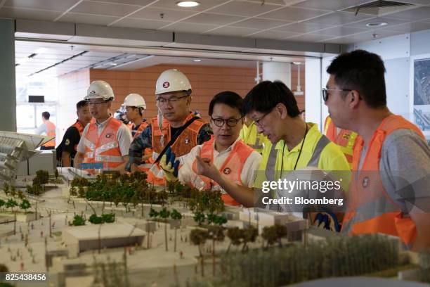 Gary Chan Hak-kan, member of the Legislative Council, center, views a model of the Guangzhou-Shenzhen-Hong Kong Express Rail Link at the West Kowloon...