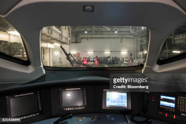 Members of the media are seen through a windshield from the control room of a Guangzhou-Shenzhen-Hong Kong Express Rail Link train in Hong Kong,...