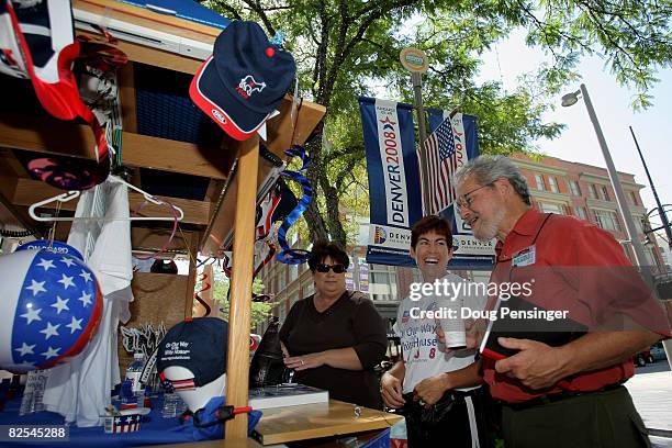 Vendor Pam Williams of Atlanta, Georgia helps customers Carmen Casados of Denver and Gary Braasch of Portland, Oregon with political souvenirs August...