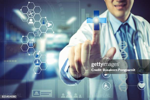 medical doctor touching virtual interface button of healthcare application - medical software imagens e fotografias de stock