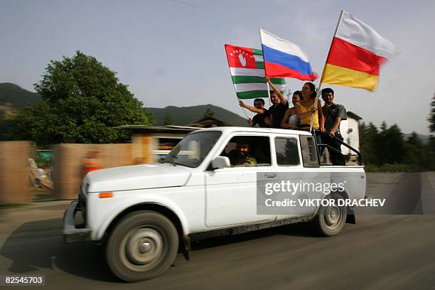 Identifiers - South Ossetians wave the flags of Russia, South Ossetia , and Abkhazia while riding in a vehicle 35 km form Tskhinvali near village...