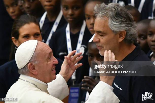 Pope Francis salutes Italian tenor Andrea Bocellias as members of the Andrea Bocelli Foundation 'Voices of Haiti' choir look on during the weekly...