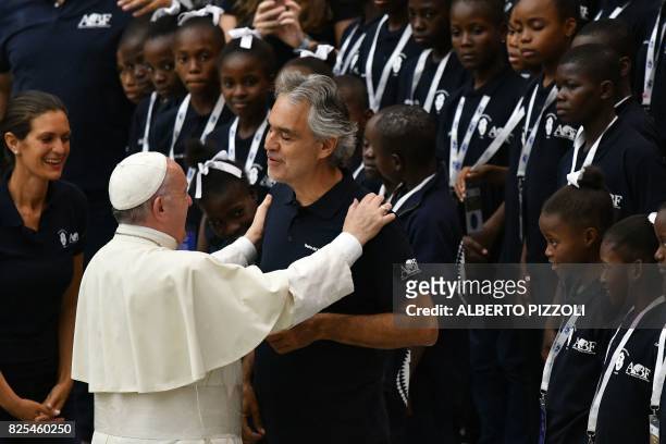 Pope Francis salutes Italian tenor Andrea Bocellias as members of the Andrea Bocelli Foundation 'Voices of Haiti' choir look on during the weekly...