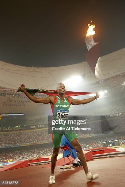 Summer Olympics: Portugal Nelson Evora victorious with flag after winning Men's Triple Jump gold medal at National Stadium . Beijing, China 8/21/2008...