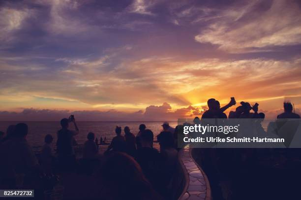 young people enjoying the sunset on a beach - fiesta en la playa fotografías e imágenes de stock