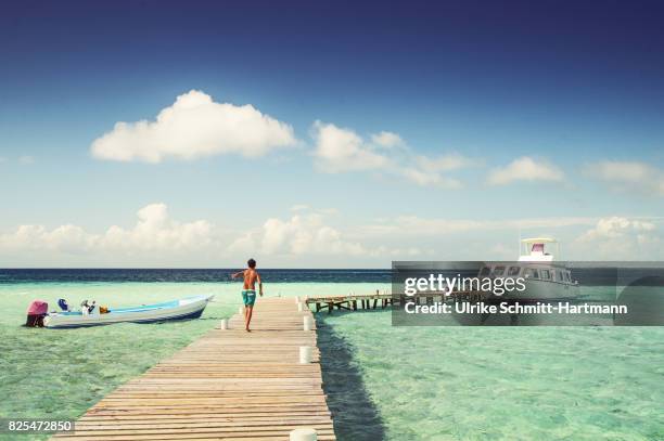 boy walking on jetty - belize stock pictures, royalty-free photos & images