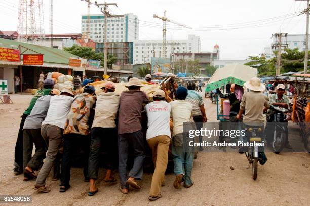 group of men pushing a vehicle - província de banteay meanchey imagens e fotografias de stock