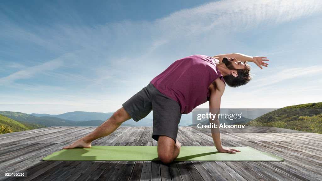 Young man practicing outdoors yoga. Side plank