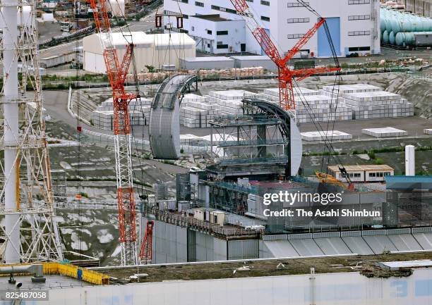 In this aerial image, a section of the half-tubular shaped roof is installed over the No.3 reactor building of the Tokyo Electric Power Co's...