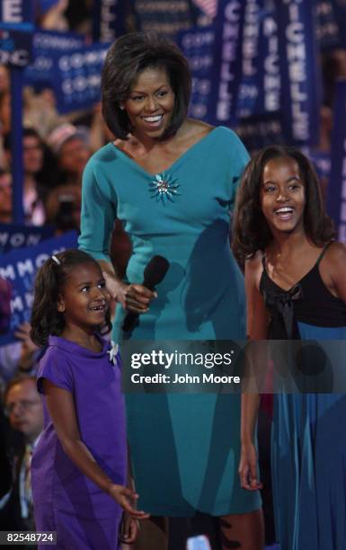 Michelle Obama , wife of presumptive Democratic nominee U.S. Sen. Barack Obama , stands with her daughters Sasha and Malia on stage during day one of...