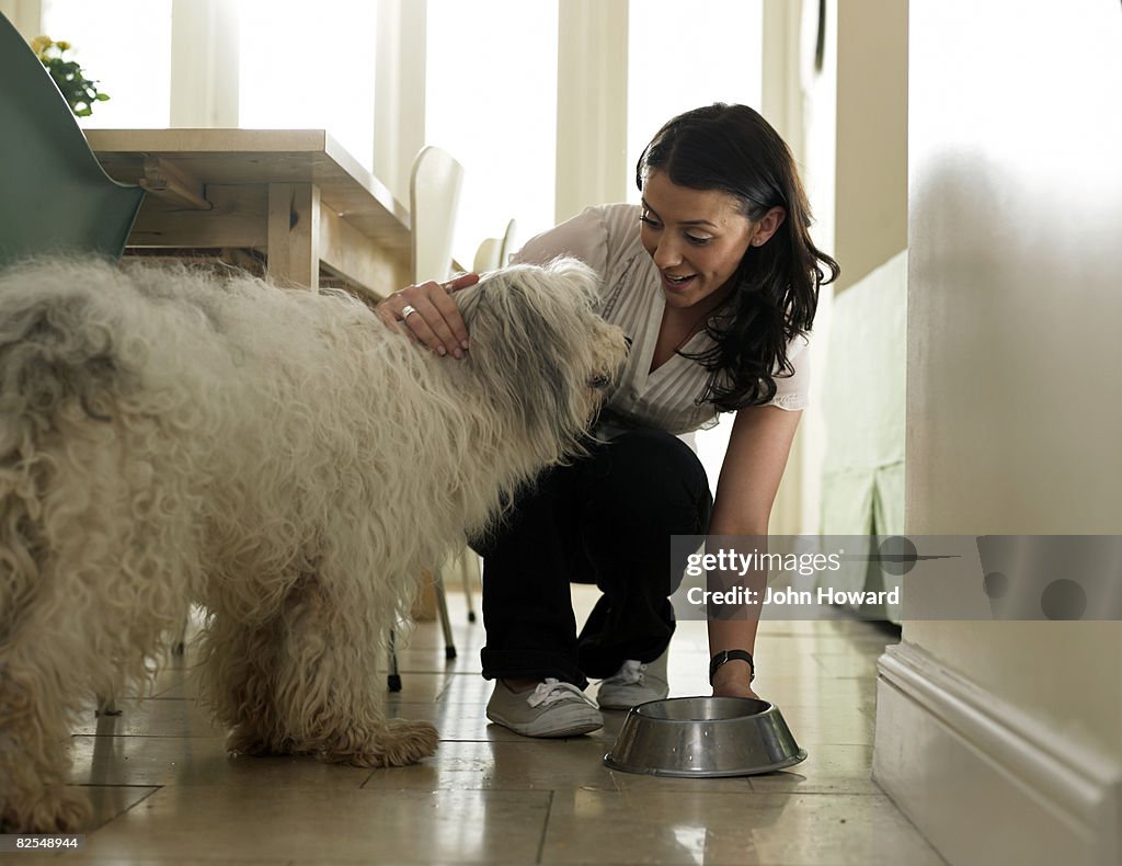 Woman putting water bowl down for her dog