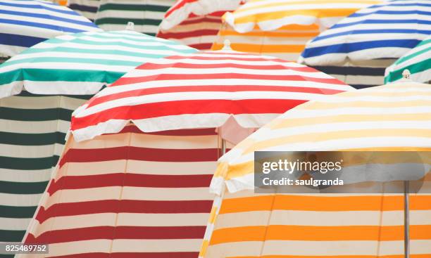 beach tents - multi coloured umbrella stock pictures, royalty-free photos & images