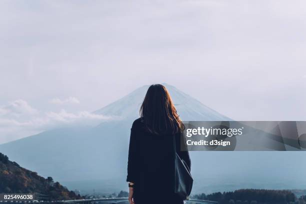 rear view of woman overlooking at mount fuji against clear sky - woman from behind stock pictures, royalty-free photos & images