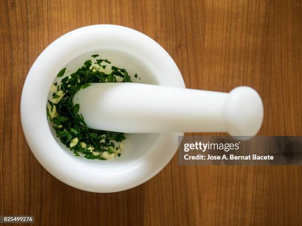 maja and mortar on the kitchen table with garlic and crushed parsley. spain - mortel bildbanksfoton och bilder