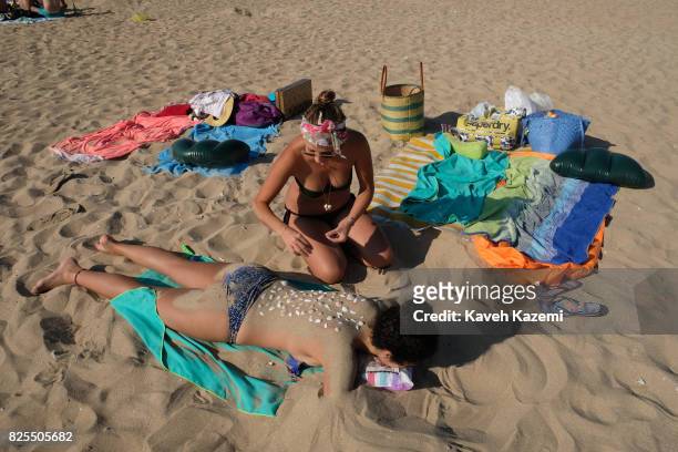 In the stronghold territories of Hezbollah the Lebanese Shi'a Islamist militant group and the border with Israel a woman in bikini lies on the sandy...