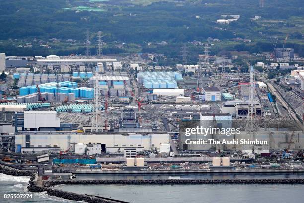 In this aerial image, a section of the half-tubular shaped roof is installed over the No.3 reactor building of the Tokyo Electric Power Co's...