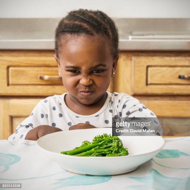 young african girl not wanting to eat her food. - stubborn stock pictures, royalty-free photos & images