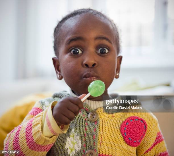 young african girl with a lolly pop. - lollipop stock pictures, royalty-free photos & images