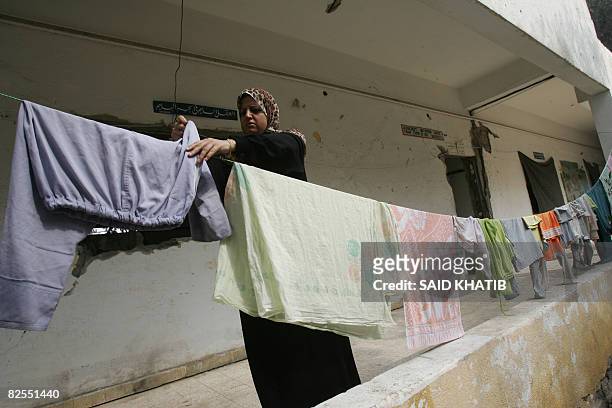 An Egyptian woman stranded in the Gaza Strip due to the closure of the crossing between southern Gaza and Egypt, hangs clothes at a school in the...